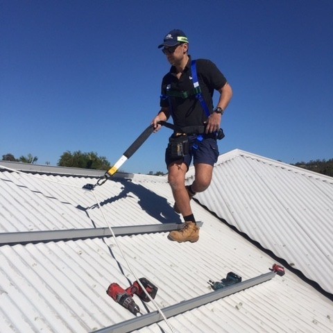 Electrician on a house roof installing solar panels | Dawson Electric