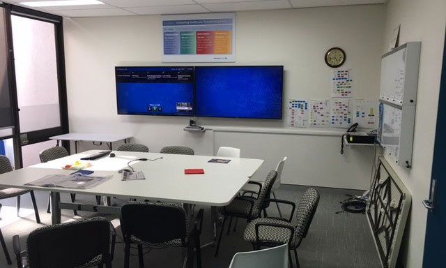 Office meeting room with conference table and two wall mounted TVs | Dawson Electric