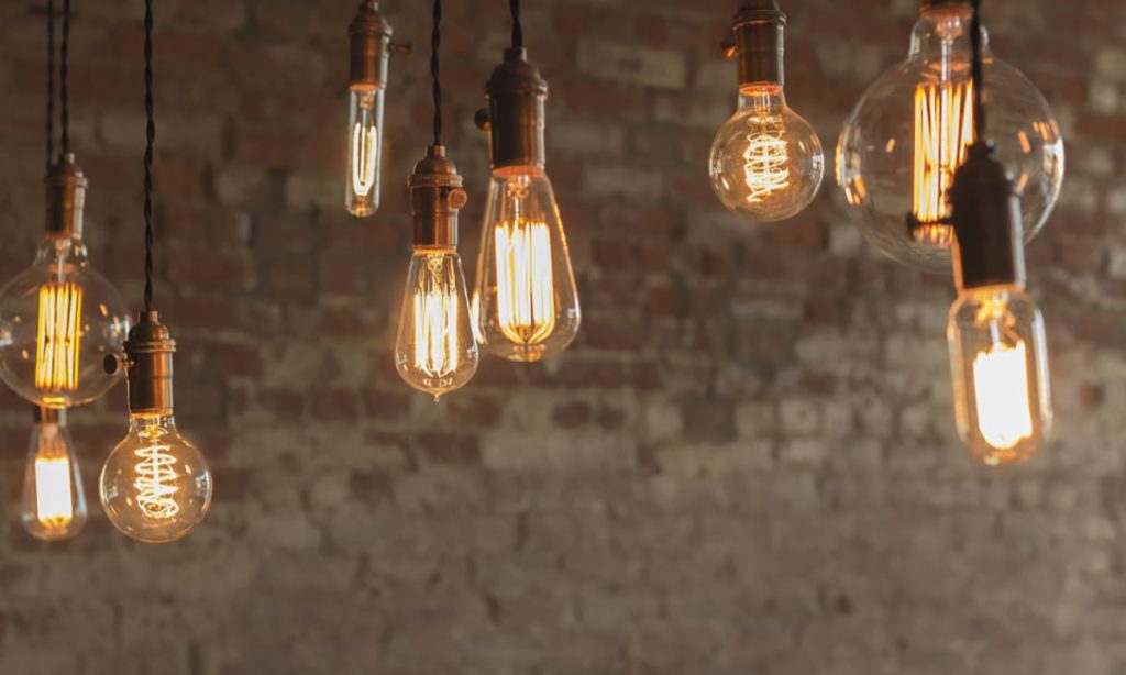 Lit Edison bulbs of different shapes with a brick wall background | Dawson Electric