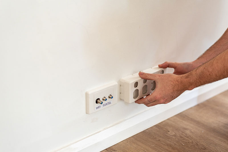 Electrician replacing the faceplate on a four outlet power point | Dawson Electric