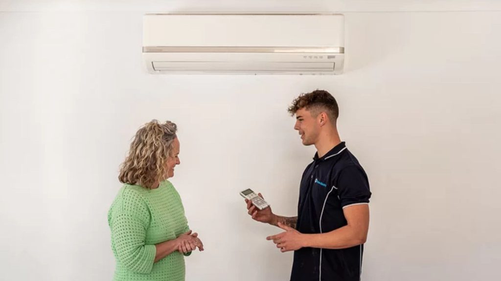 Man and Woman standing in front of air conditioning
